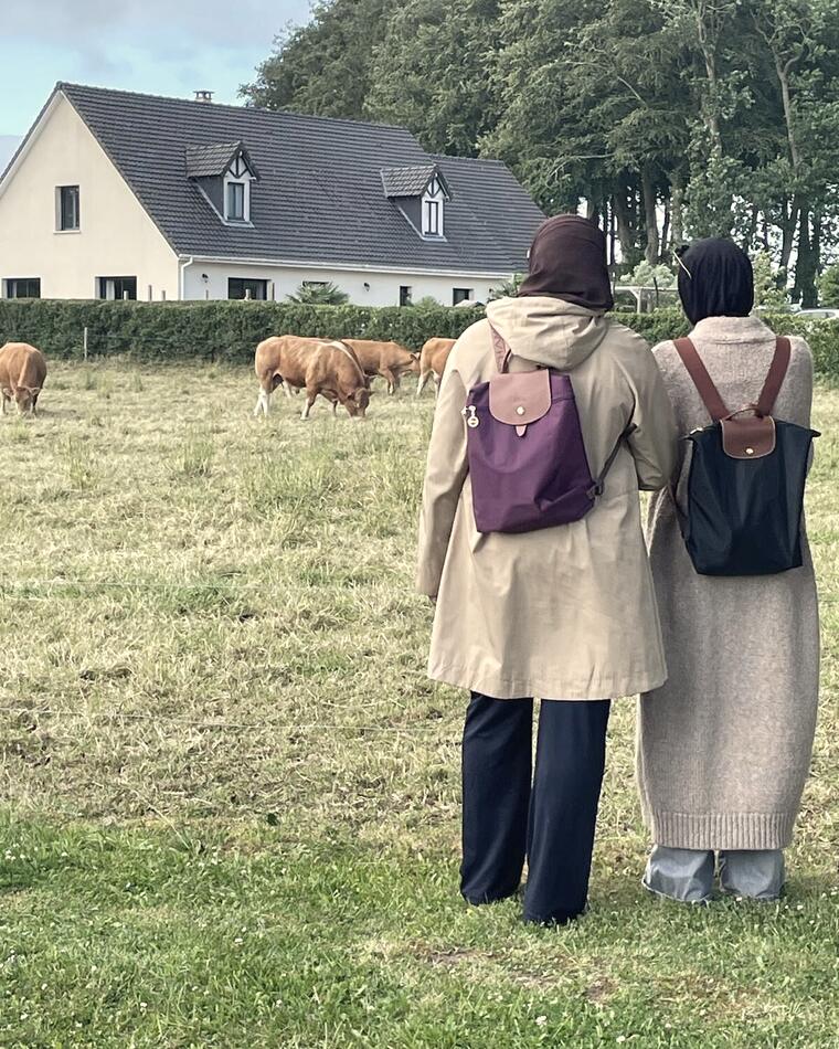 Deux femmes de dos devant la prairie et le gîte